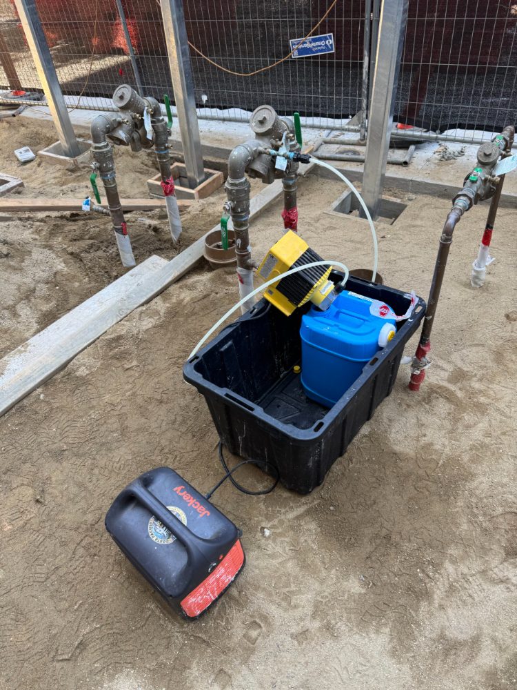 Chlorination injection pump setup at a job site for waterline disinfection